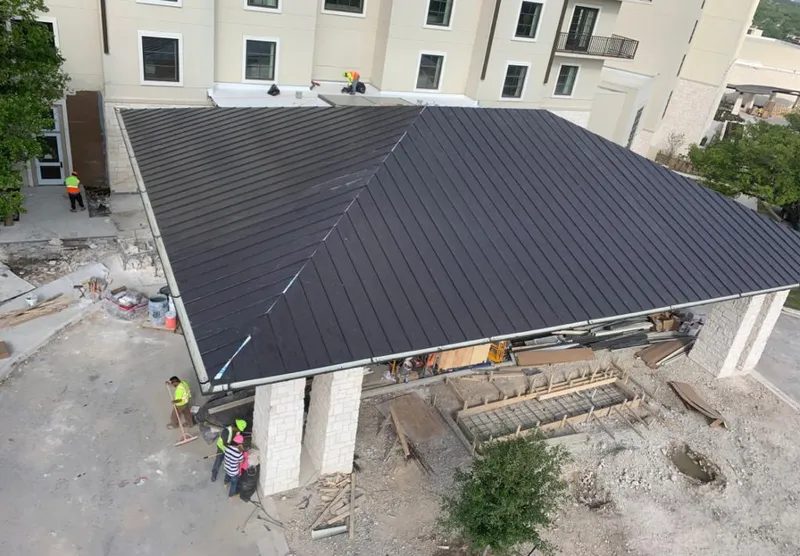Metal roofing installation team working on a commercial building in Charlestown